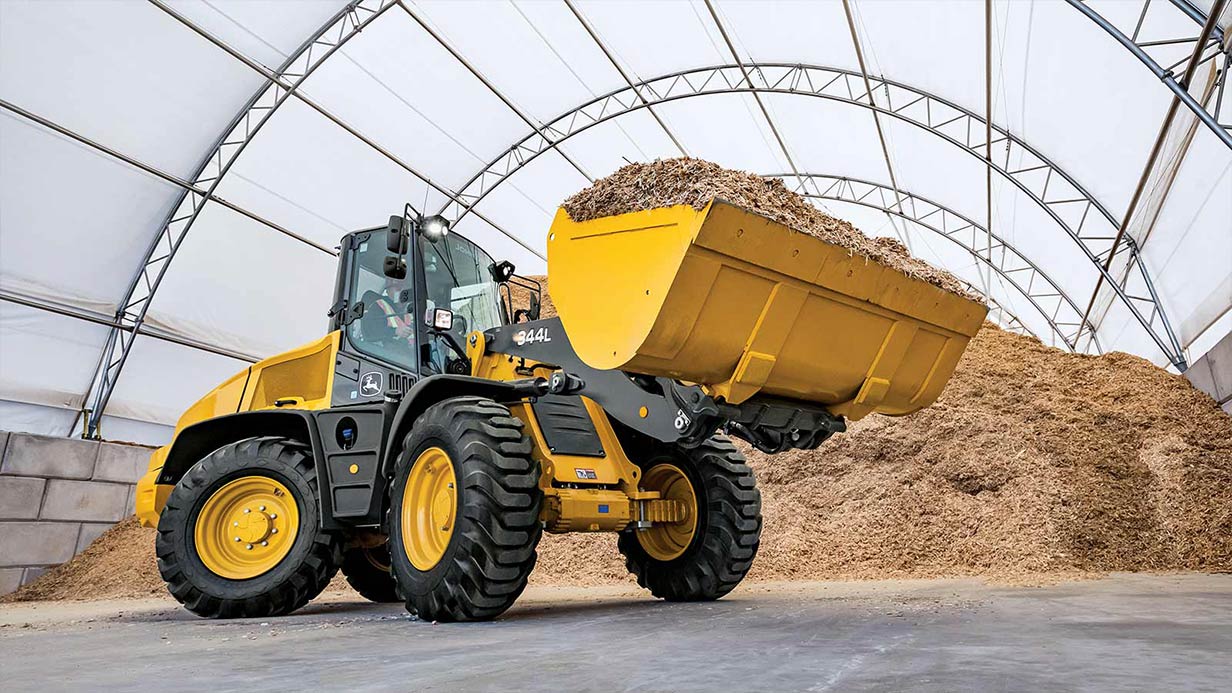 A John Deere 344L Compact Wheel Loader shown with a fully loaded bucket