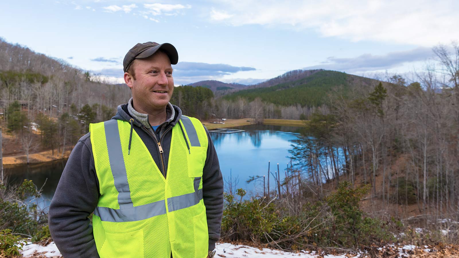 Time Ferris, Owner of Defiant Marine, stands smiling in front of a lake.