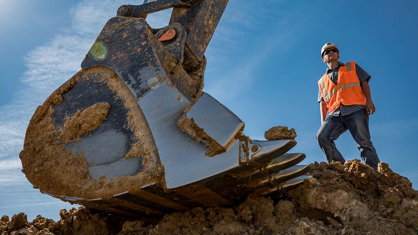 Tyler Cagle overlooks the job site next to the bucket of a John Deere 670G LC Excavator