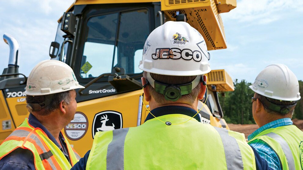workers stand around a dozer