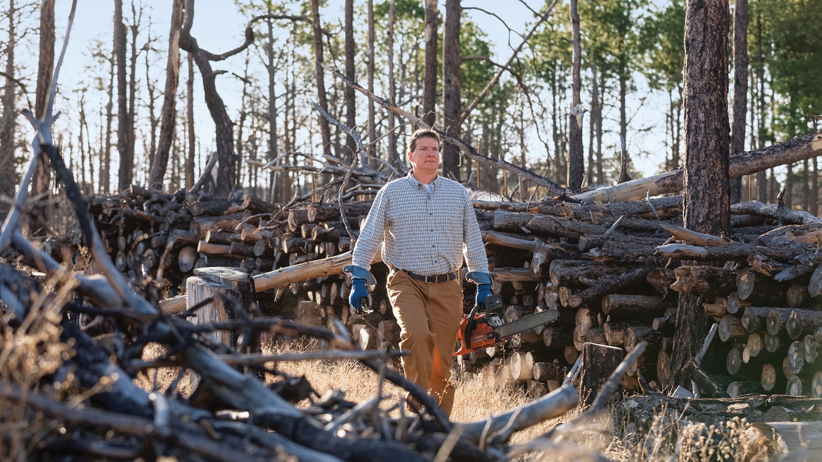 Neil Behnke, winner of the Small Machines. Big Impact. contest, walks through remains of the Black Forest in Colorado.