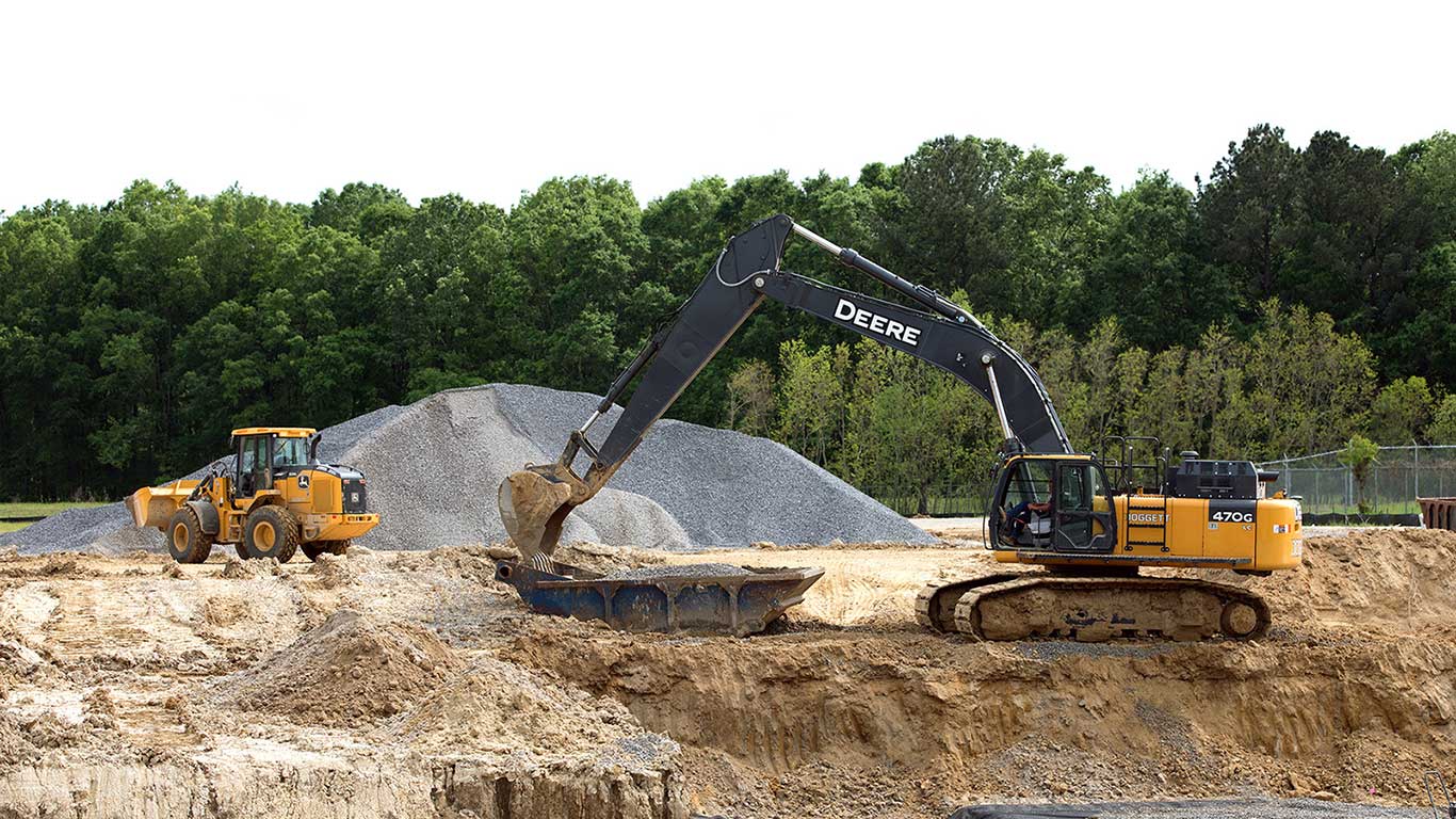 A John Deere wheel loader and 470G Excavator moving earth at a wastewater jobsite