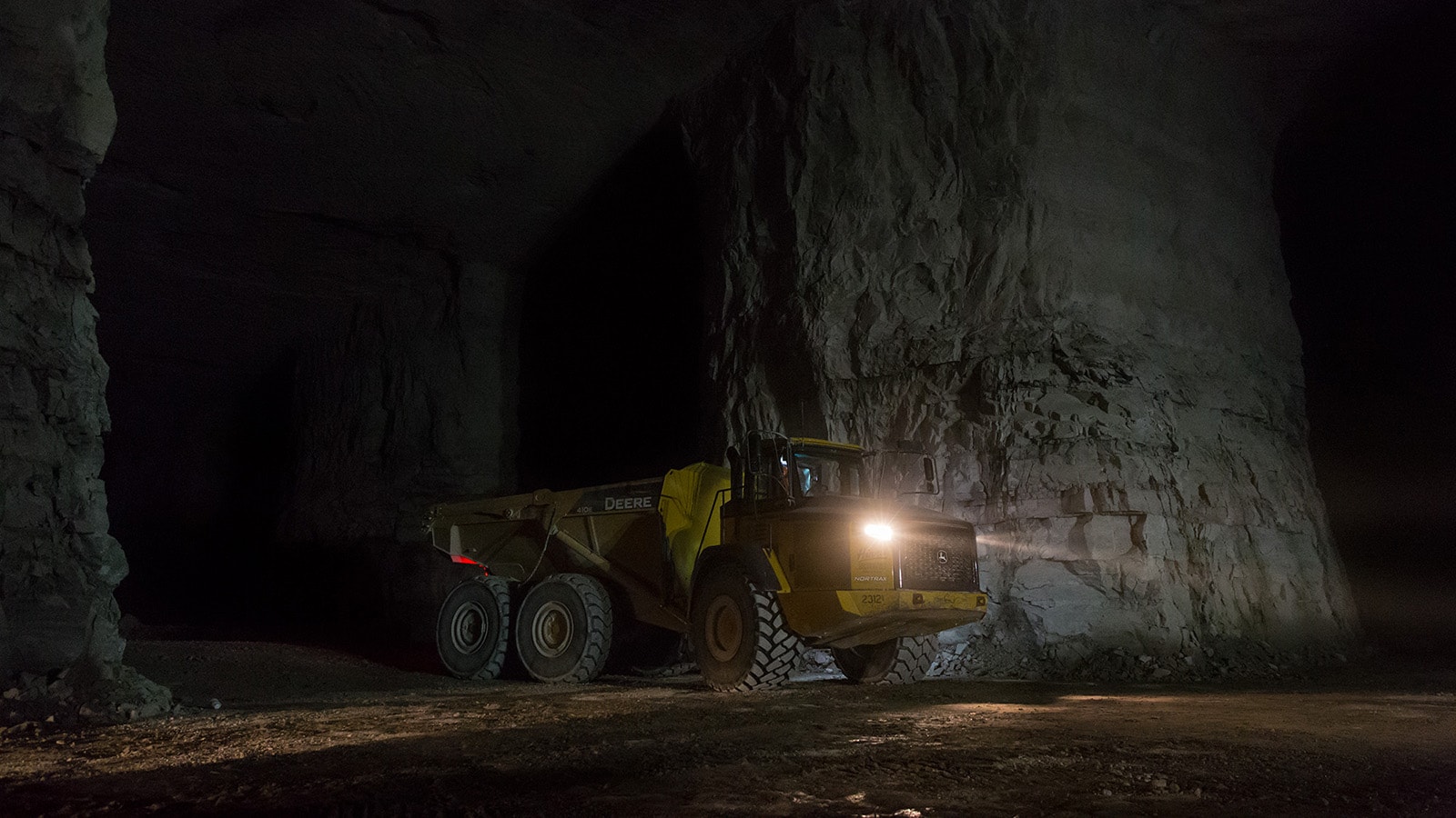Articulated dump truck drives through a mine