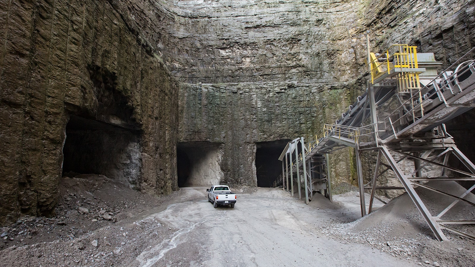 A pickup truck drives into the mine entrance