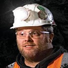 A head shot of Justin Voss wearing a hard hat and safety vest