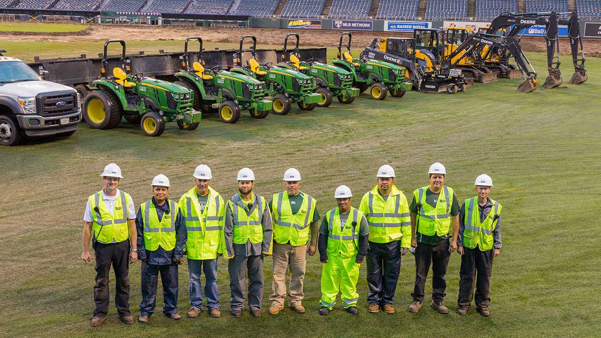General contractor Steve Bush stands with his team in front of their all-Deere equipment fleet.