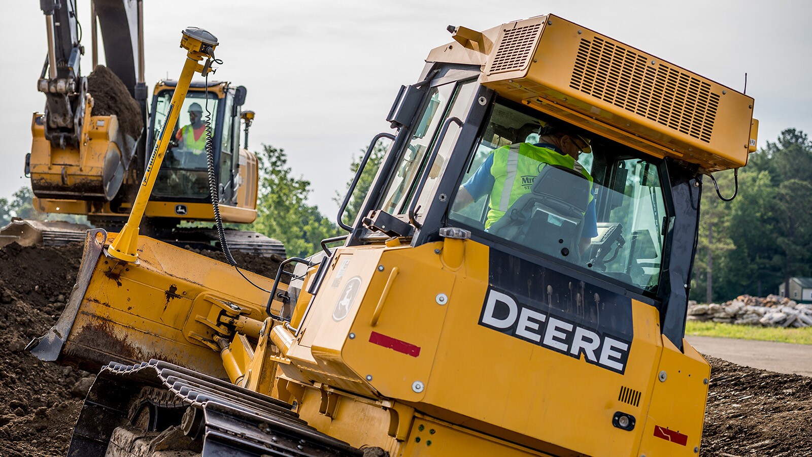 Close up of the back of a dozer pushing dirt up to an area for an excavator to scoop it up