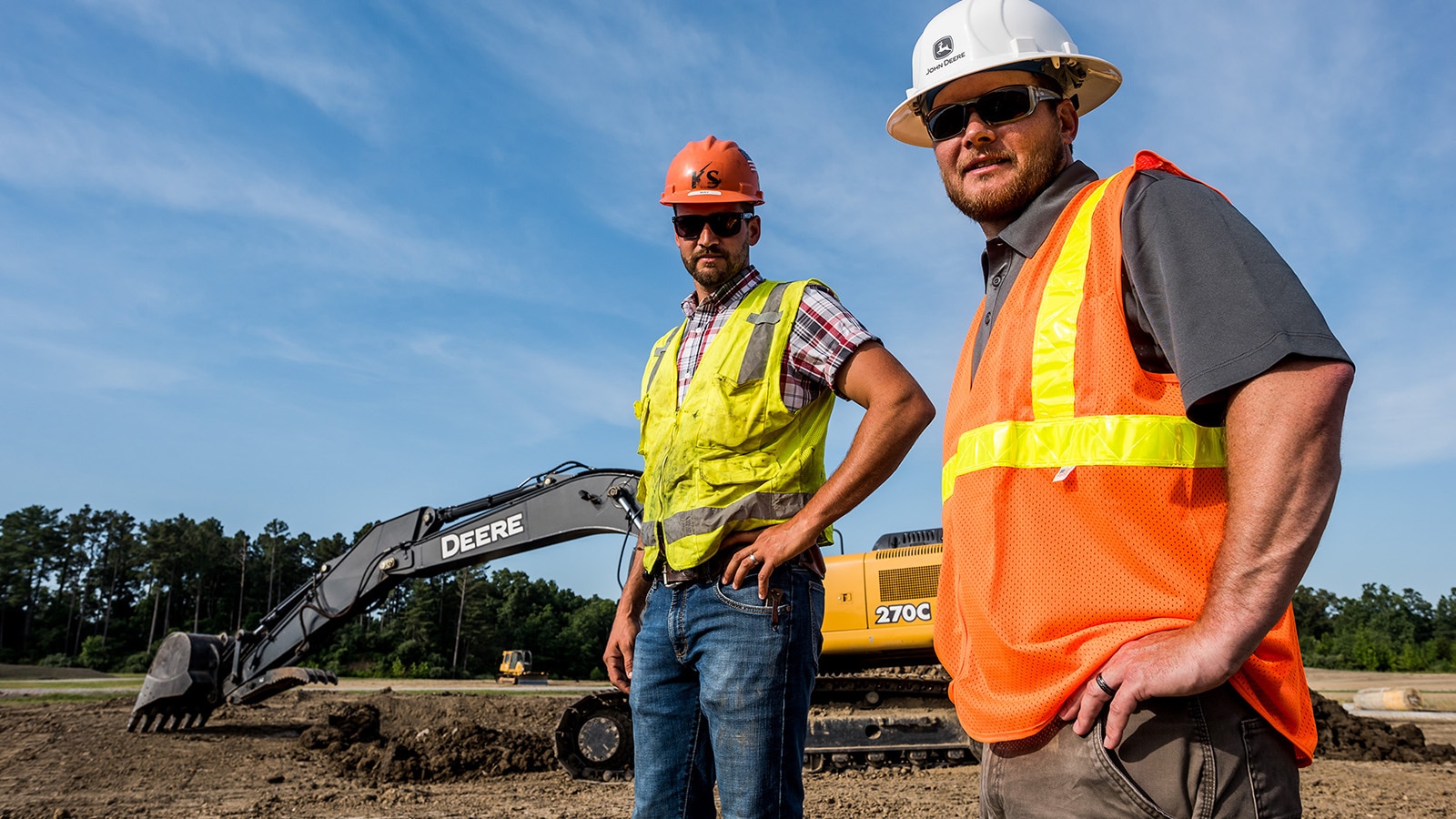 Noah Ridgway and Justin May pose in front of a 270C Excavator
