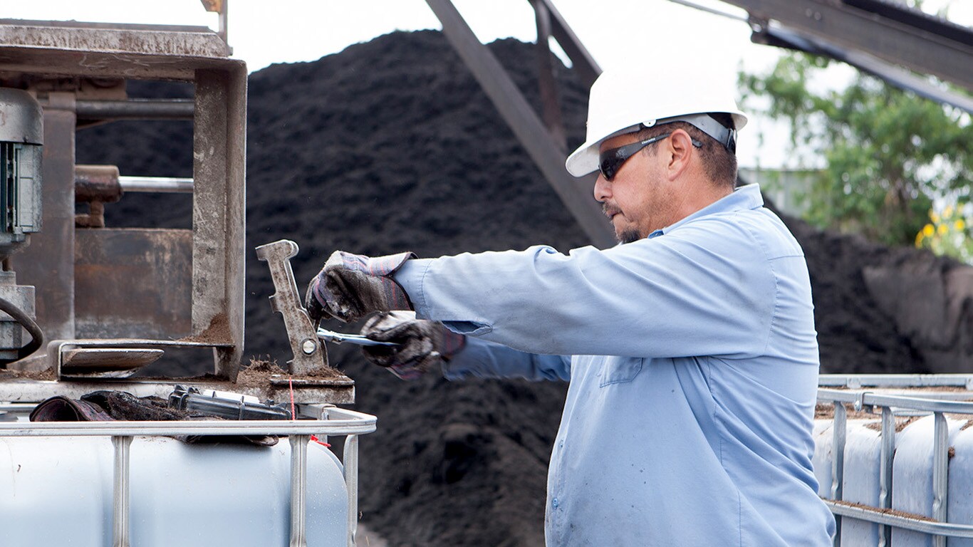 A worker pulls a latch on a tank of dye