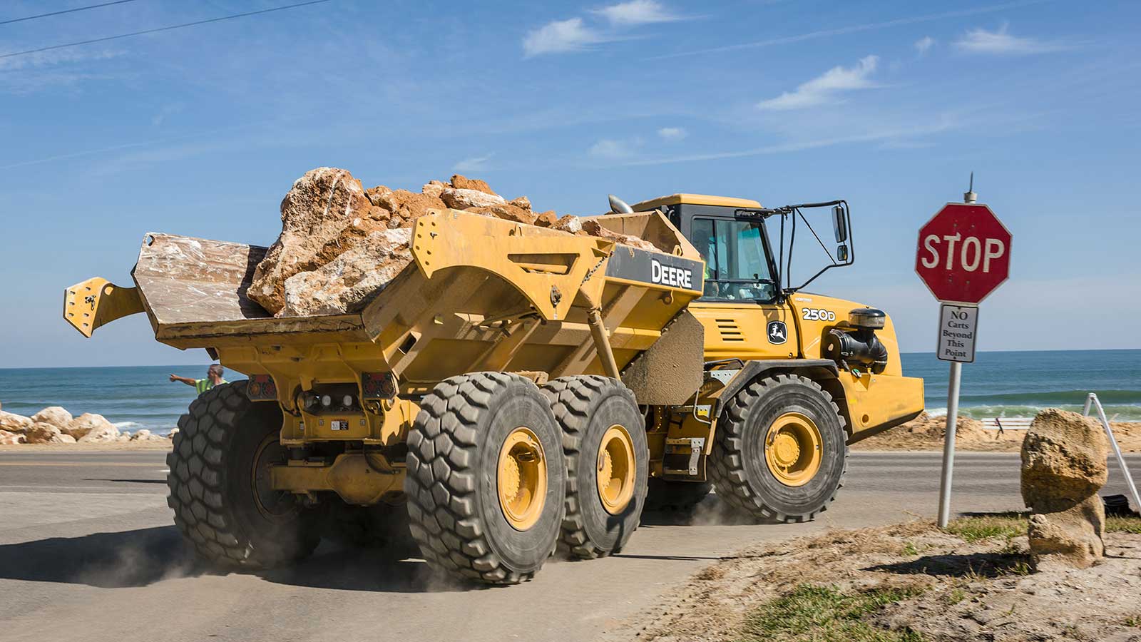250D Dump Truck hauling boulders by the beach