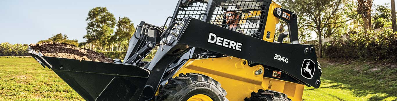 332G Large Skid Steer pushes snow in a parking lot with a V blade attachment