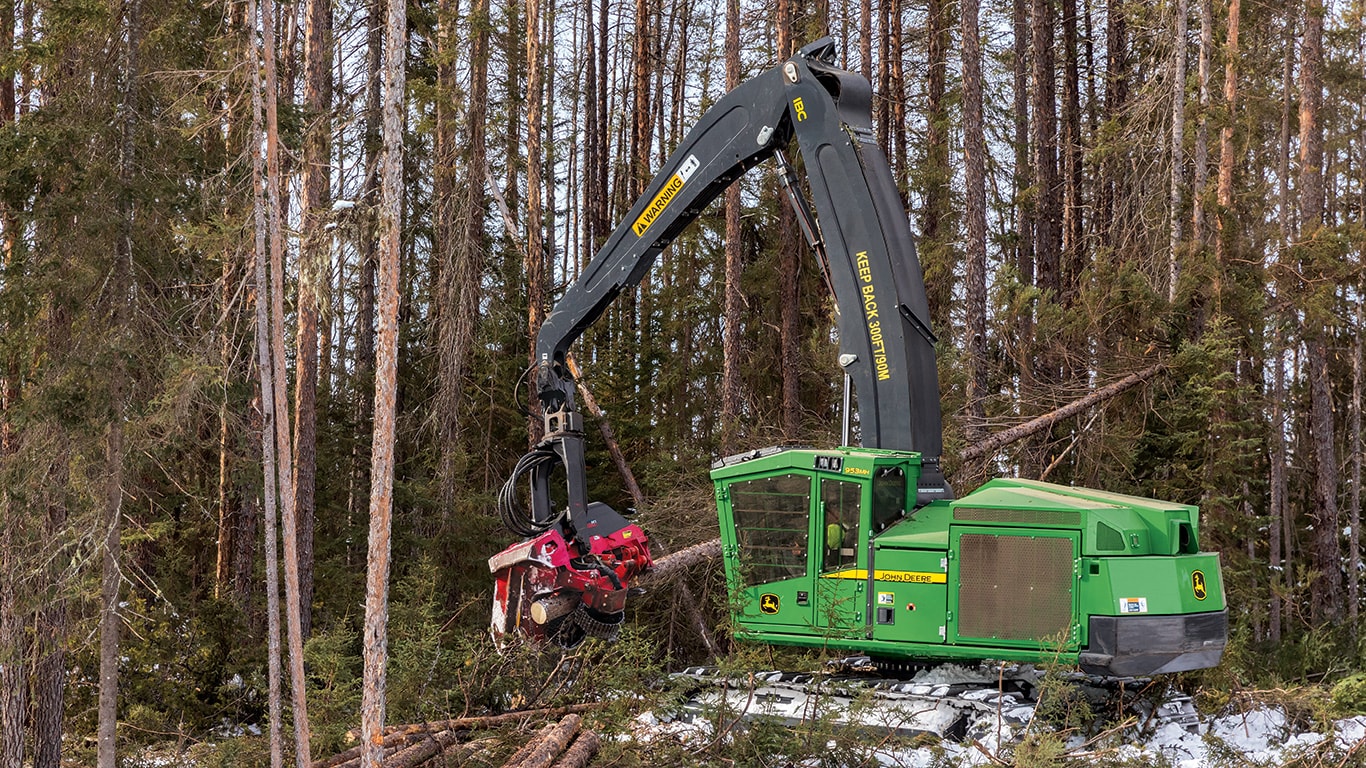 John Deere 959MH picking up cut trees at site