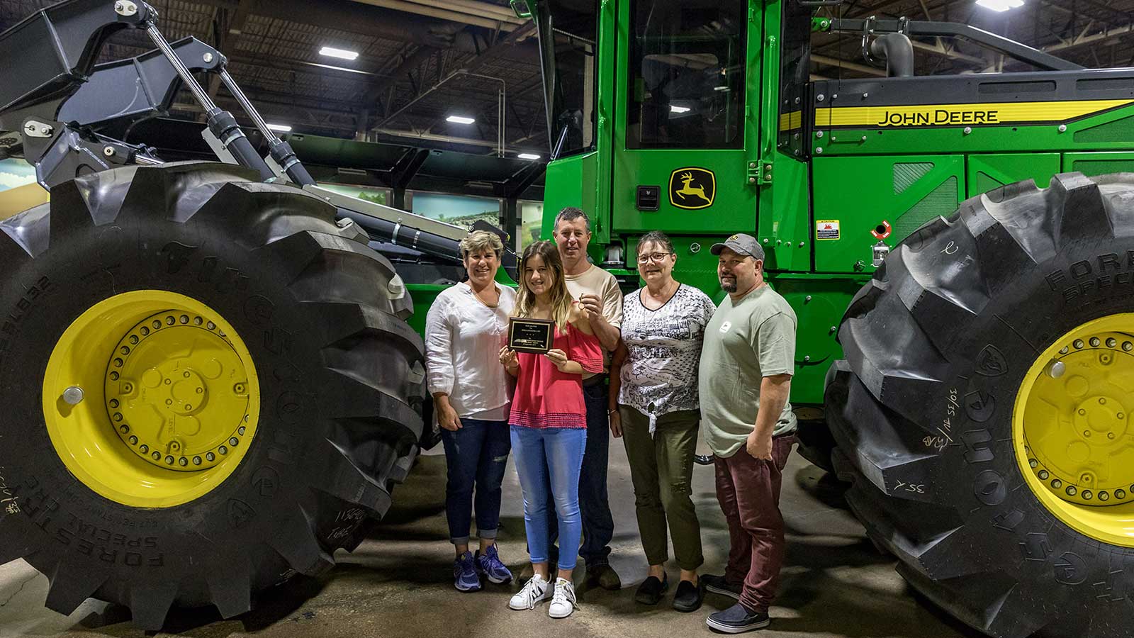 Ferguson and his family line up for pictures next to their new 848L Skidder as it comes off the factory line.
