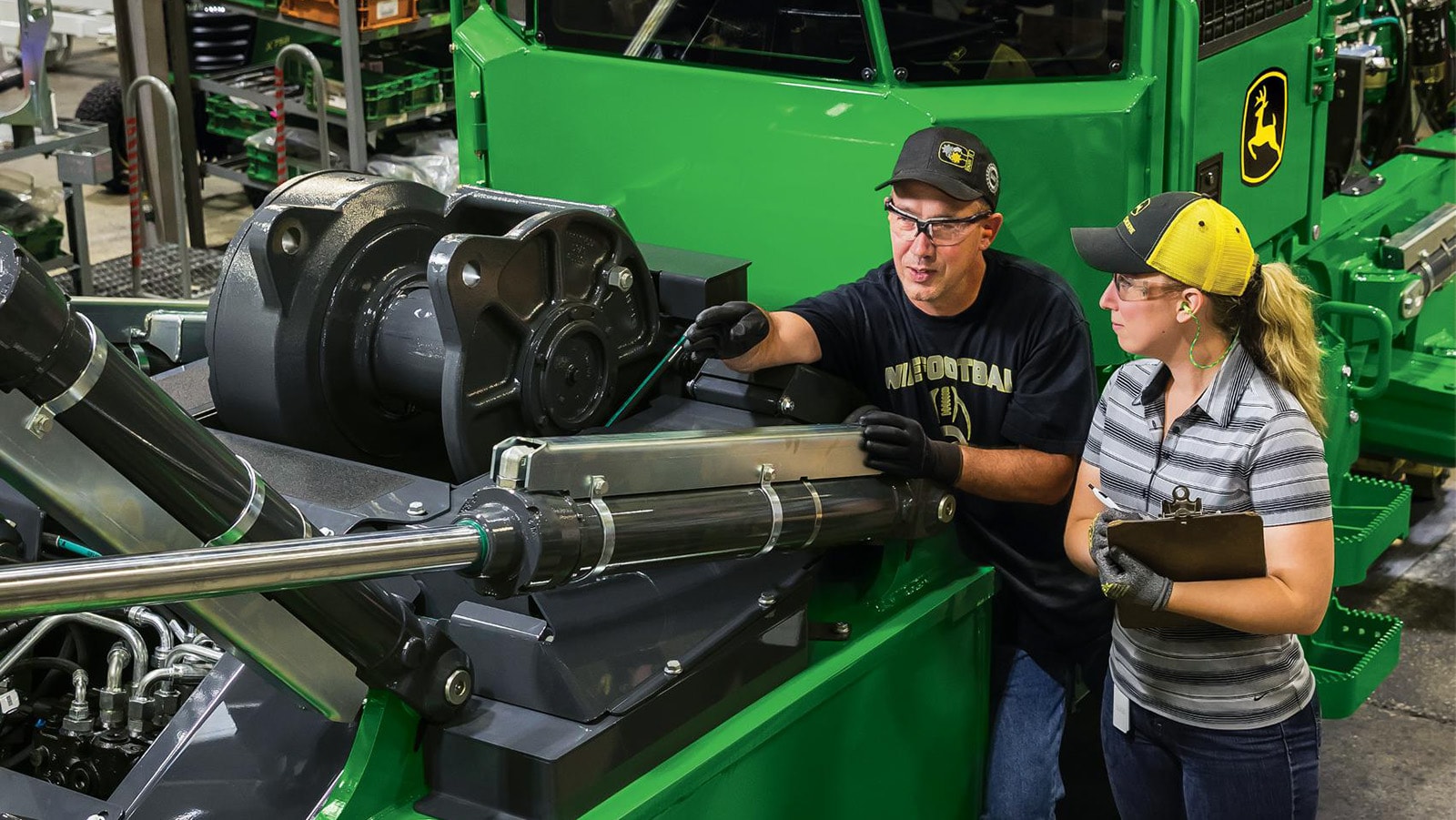 two factory workers talk while looking at a 748L-II Skidder