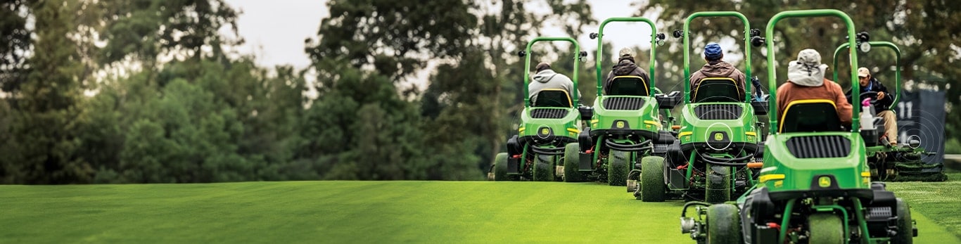 four people driving four mowers away and one person driving one mower toward the other four on a golf course