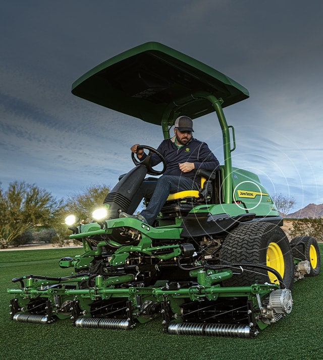 person driving mower on golf course