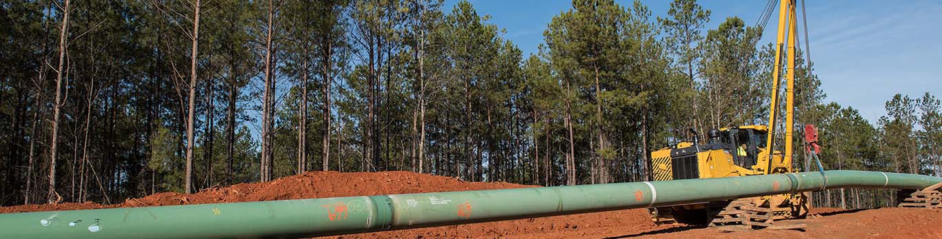  pipelayer-ready crawler laying pipe on a work site.