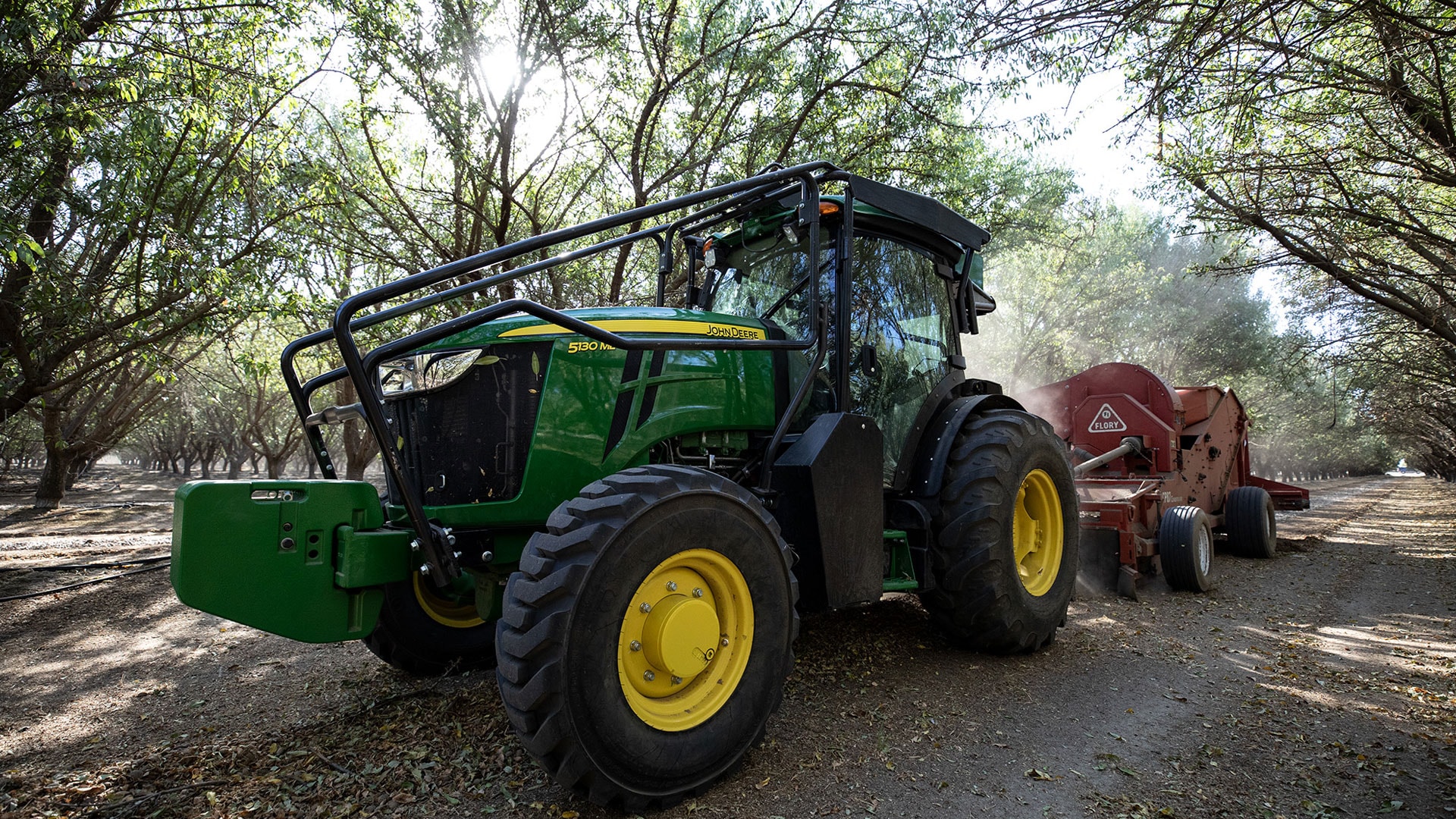 John Deere tractor working in orchard.