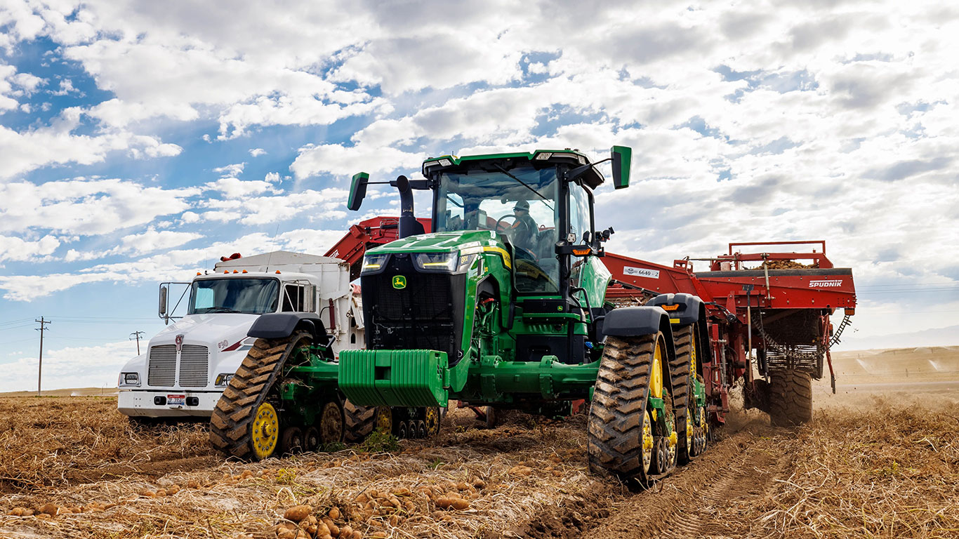 Track tractor with wide spacing working in field.