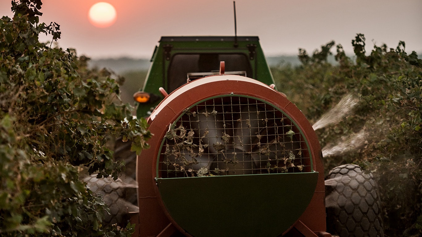 Tractor with pull-type sprayer in orchard spraying