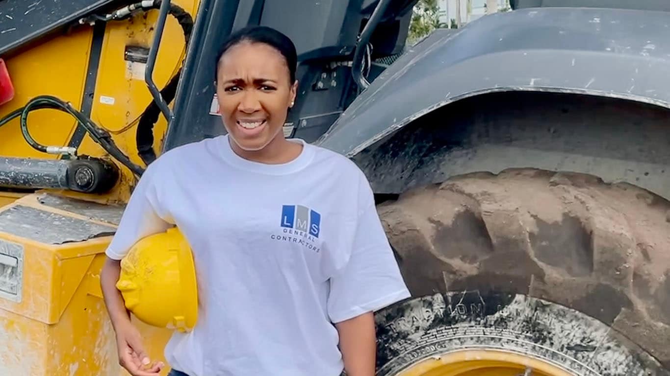 Photo of Jennifer Todd in front of John Deere Backhoe Loader