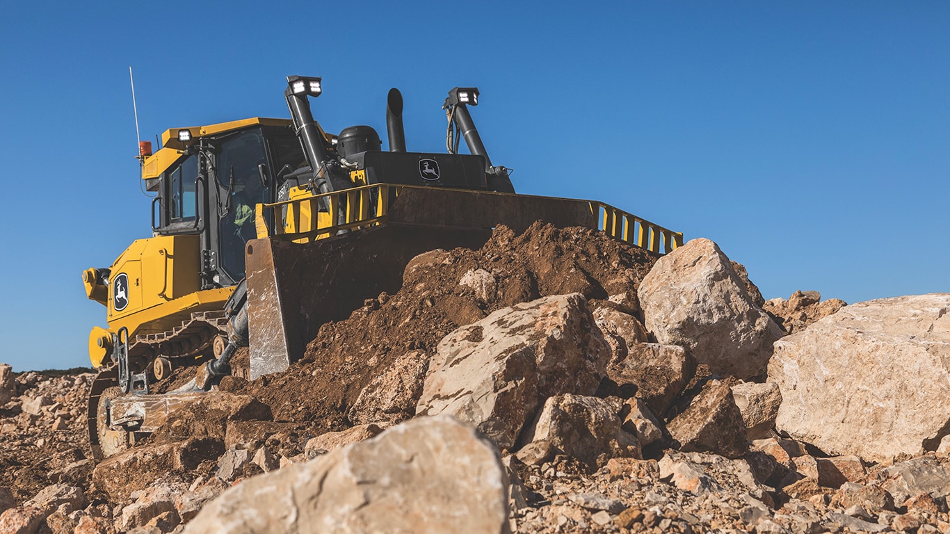 Action shot of the 1050 P-Tier Dozer pushing rocks and dirt.
