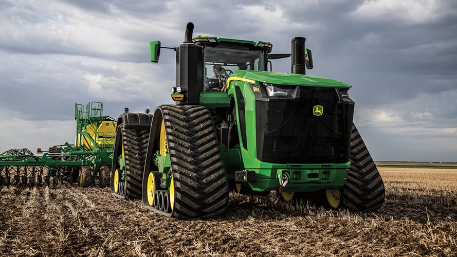 A farmer operates one of the new John Deere tractors in field