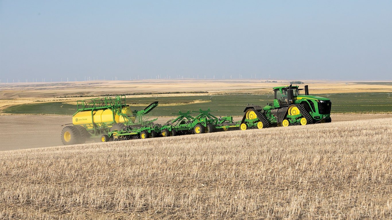 Side view of the new 9RX 830 tractor pulling a N560F ProSeries  Air Hoe Drill and new C850T air cart through the field.