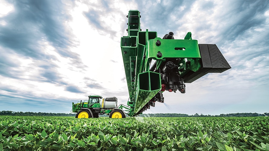 A wide angle view of a John Deere sprayer in a farm field