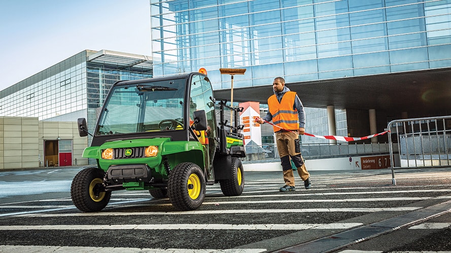 A utility worker approaches a parked Gator Utility Vehicle