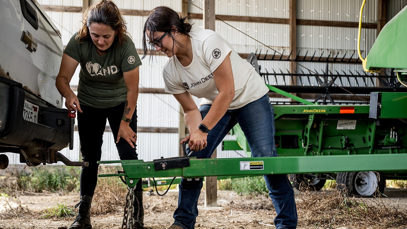 Betsy and Sam connect a John Deere implement to a pickup truck
