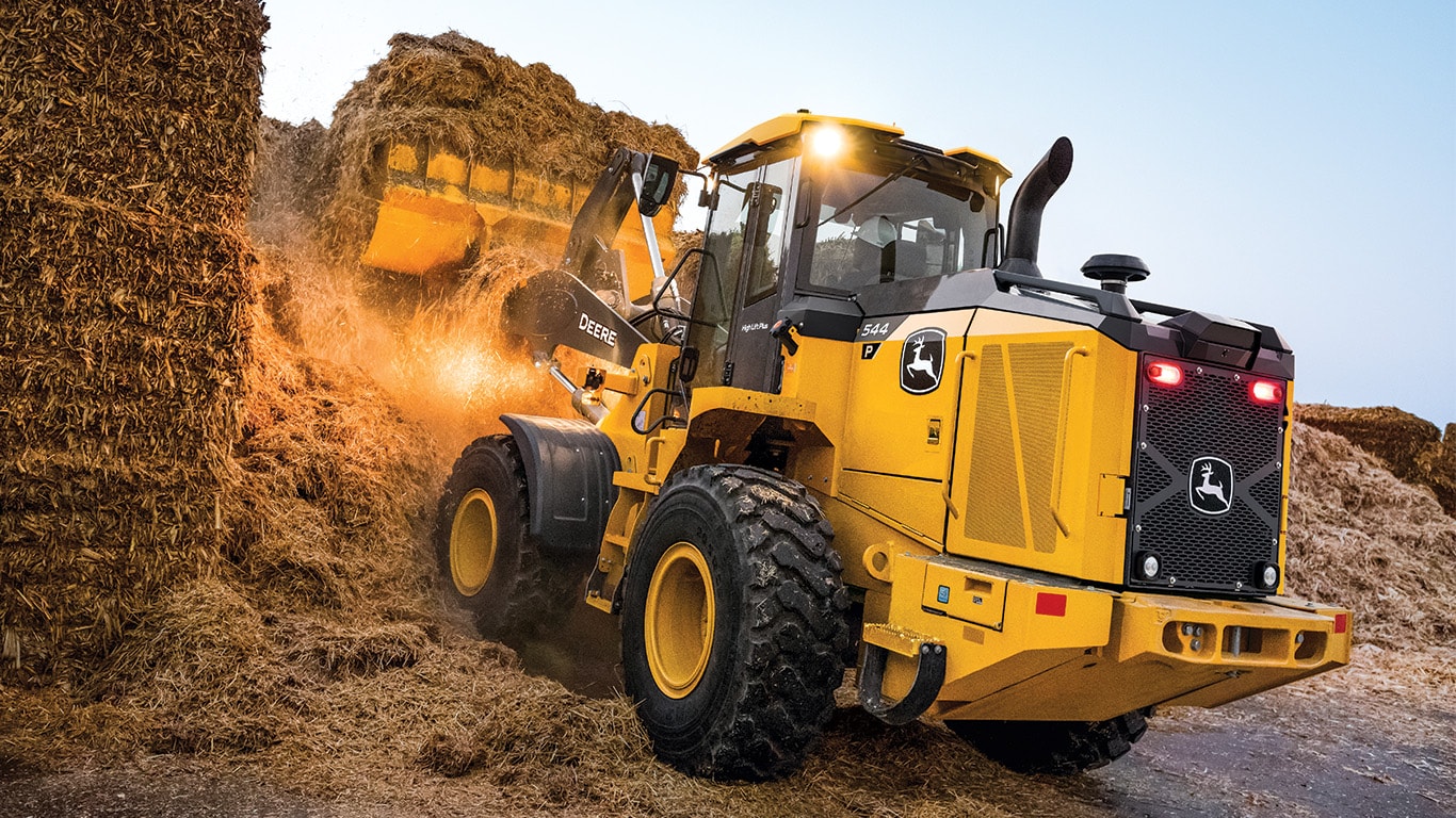 John Deere 544 P-Tier Wheel Loader scooping straw into a bucket