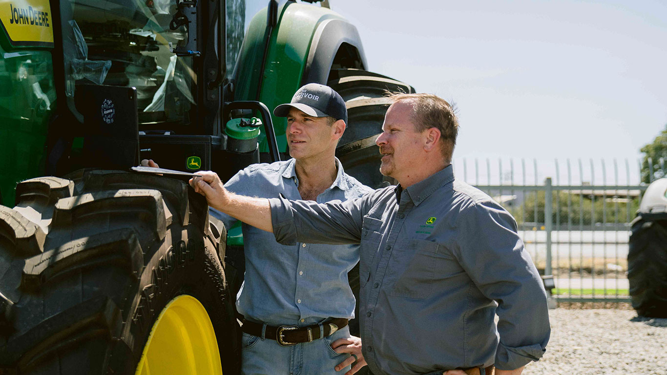 Danny Bernstein, CEO of the Reservoir and John Deere business integration manager, Sean Sundberg, look at a laptop as they discuss how John Deere's innovative world-class technology and equipment can partner with the Reservoir