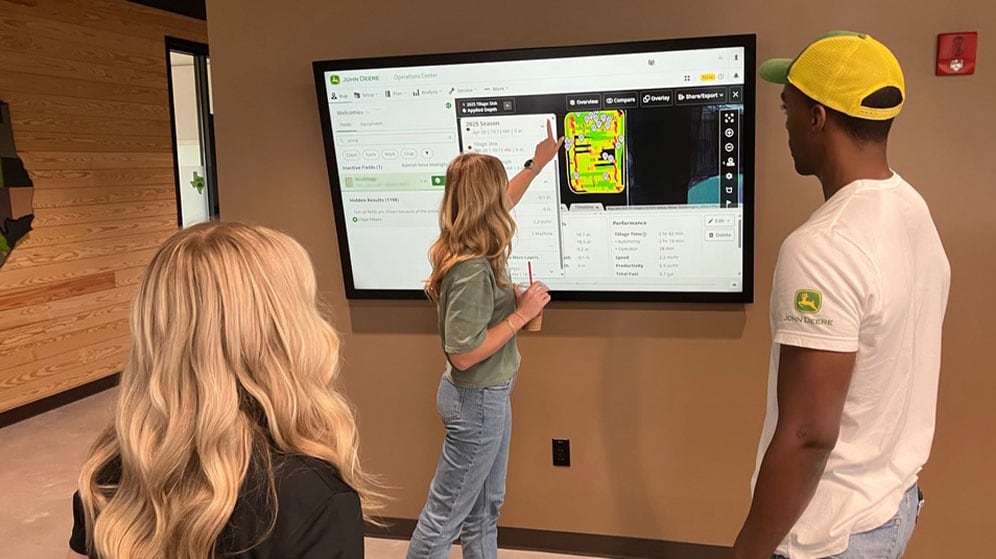 Sarah Wurden points to screen while working on software with team