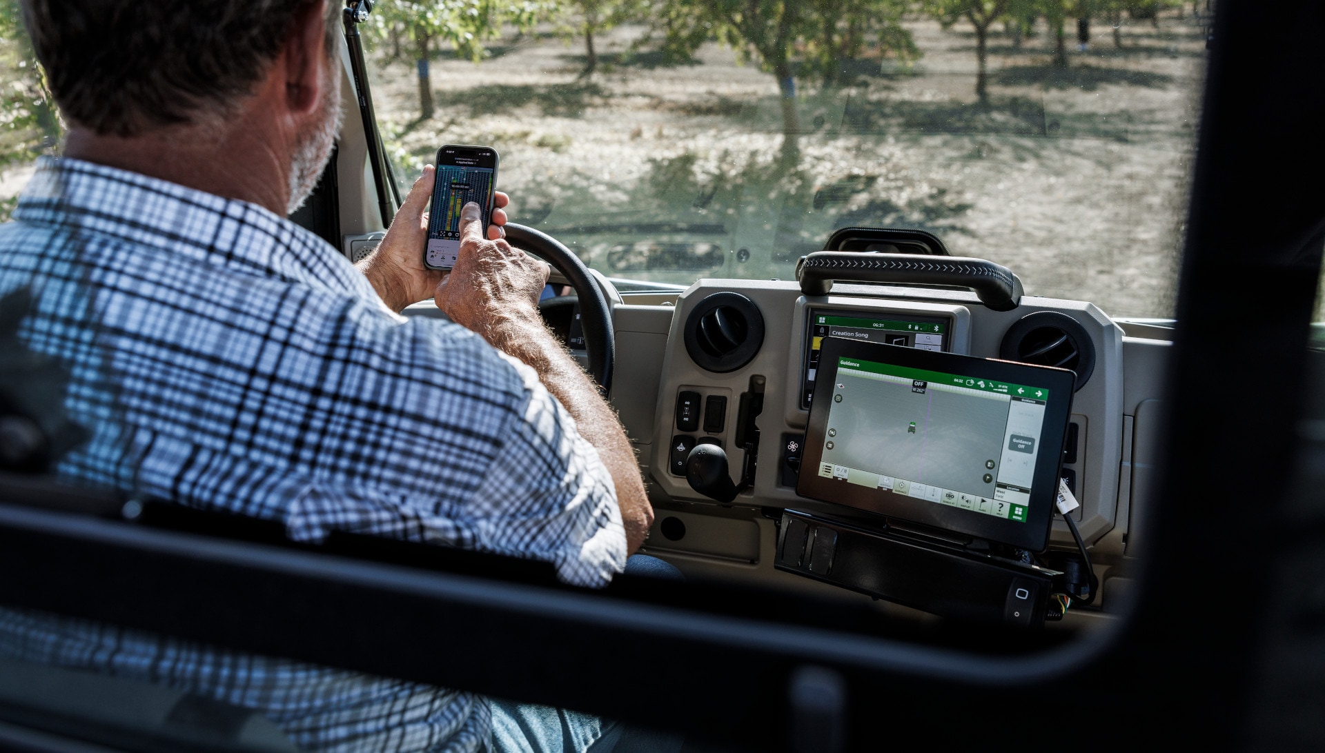 Russell Maichel using autonomous John Deere tractor in orchard