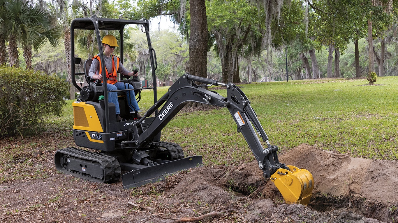 17 P-Tier Compact Excavator digging a hole in the grass.