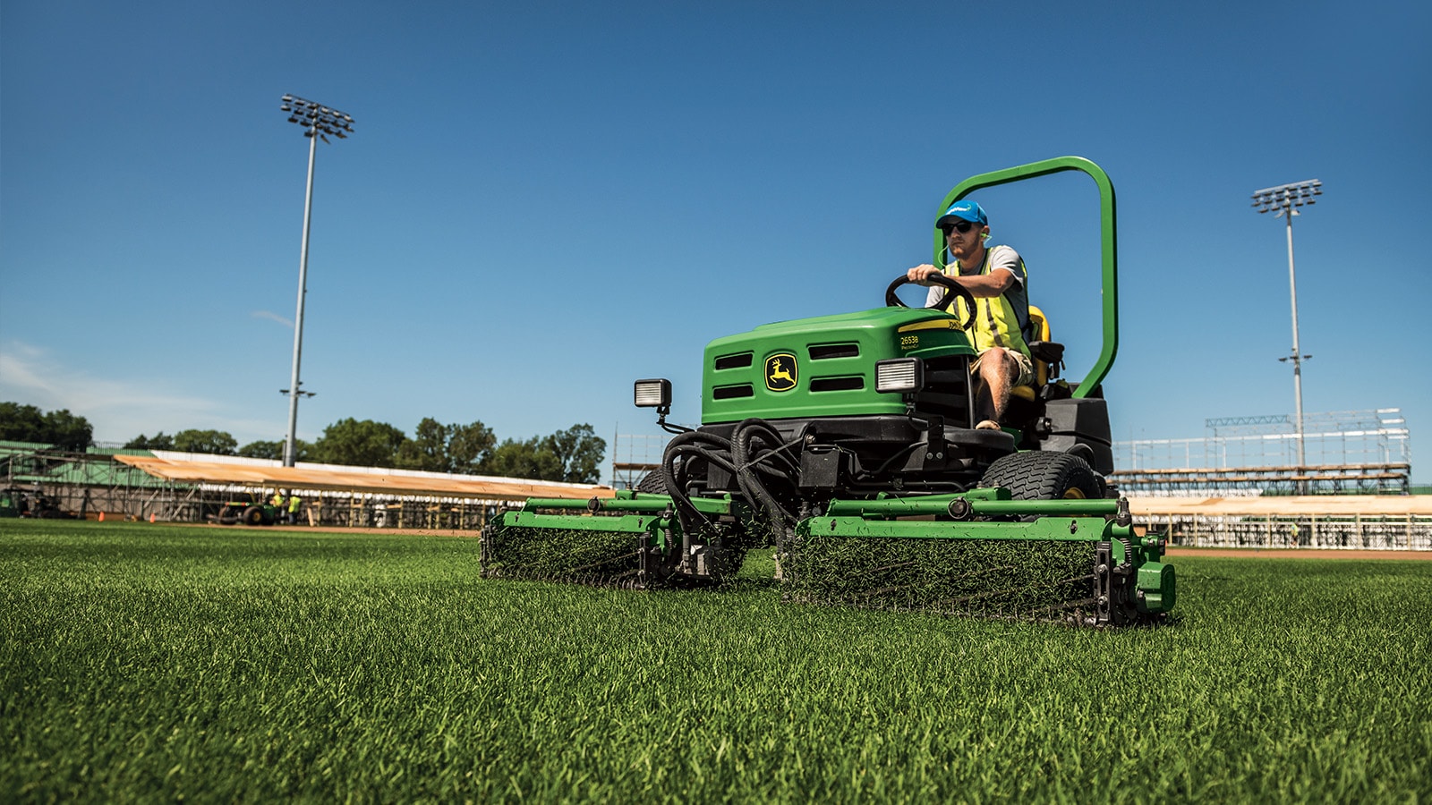 mower mows the grass in a baseball outfield