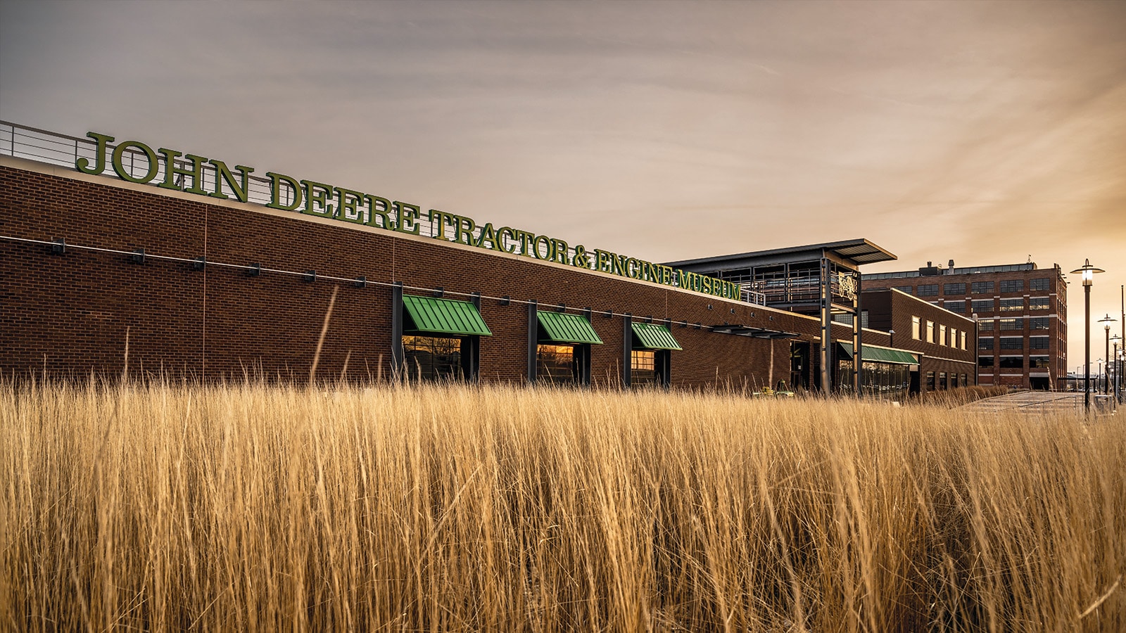 the outside of the John Deere Tractor and Engine Museum building in soft golden light