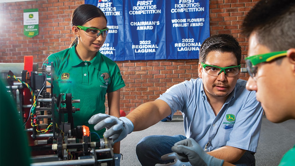 FIRST robotics students and teacher learn how to build an engineering project in school