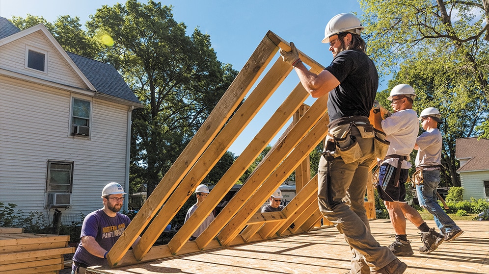 a team builds the framing of a house