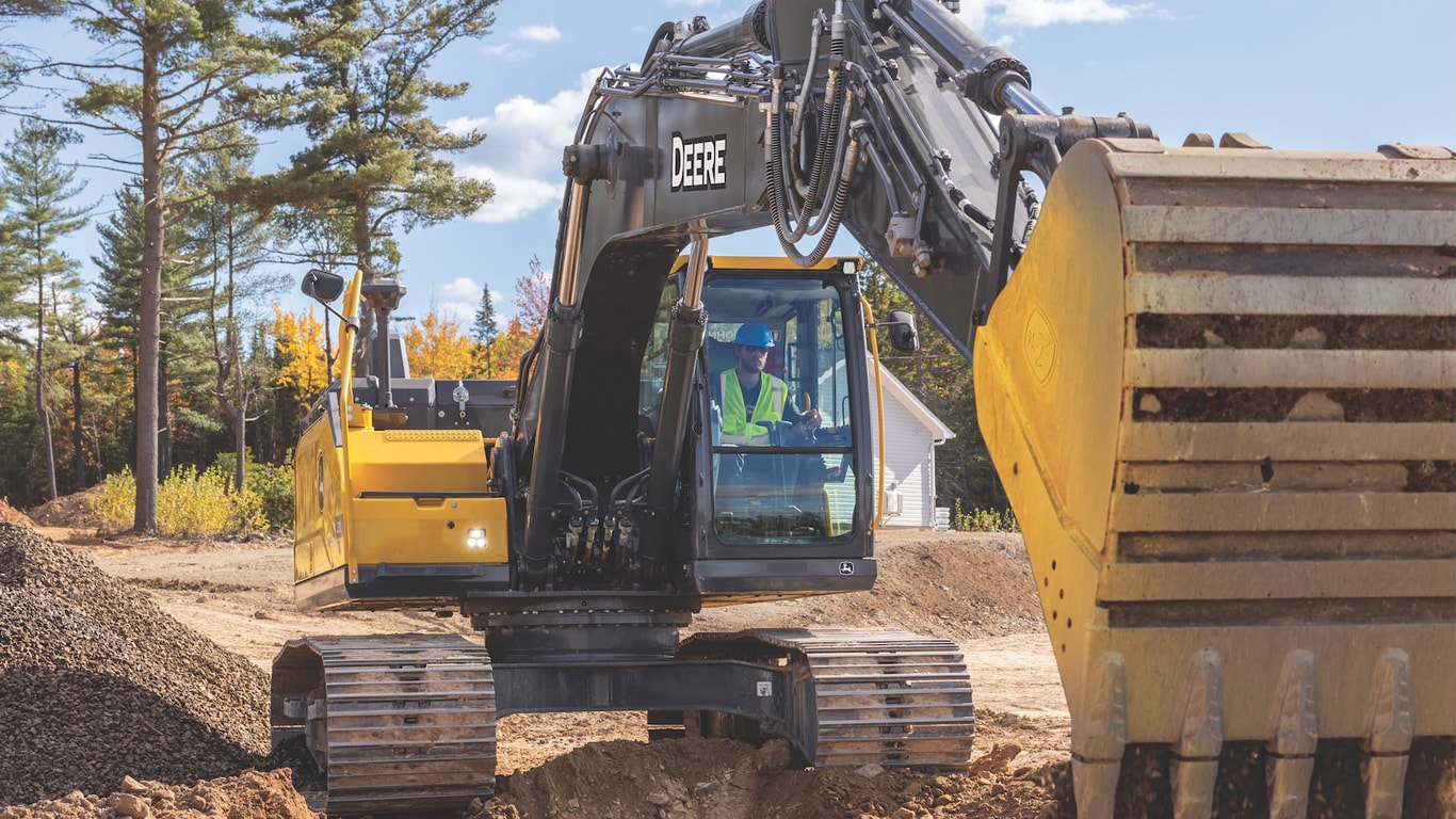 230 P-Tier excavator digging a dole and dumping dirt