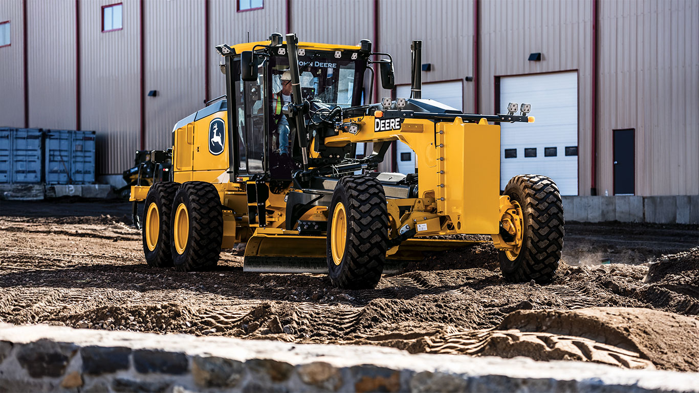 SmartGrade P-Tier Motor Grader in front of warehouse