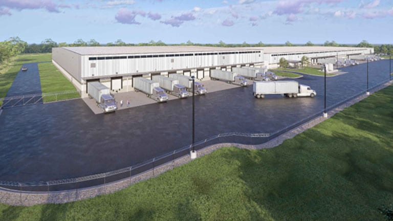 Rendering of the expanded John Deere Reman facility in Missouri, showing a large warehouse with multiple loading docks, semi‑trailers, paved yards, and landscaped grounds.