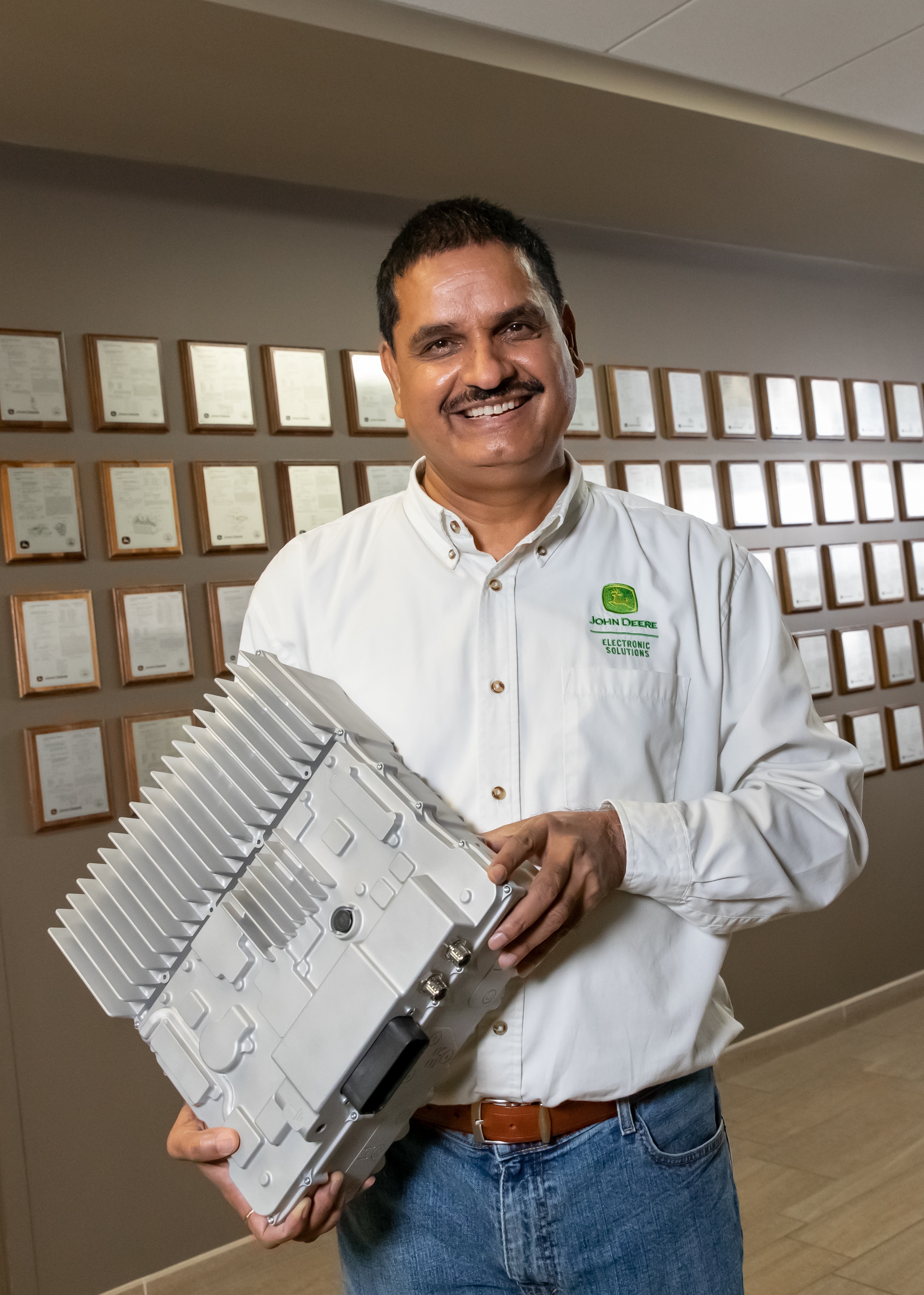 A photo of Brij Singh holding an invertor