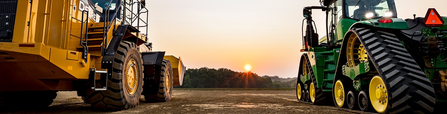 Group of employees standing with a John Deere combine