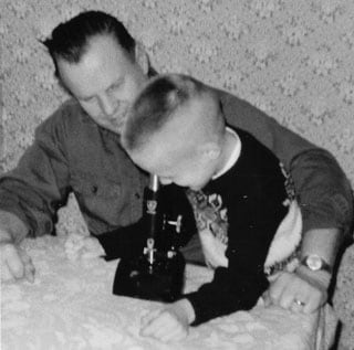 Noel Anderson using microscope as young child.