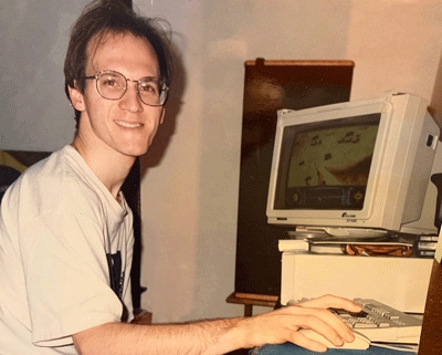 Adrian Rantilla as a young adult sitting by computer.