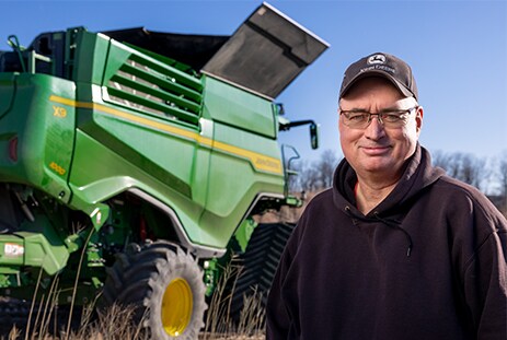 Glenn Pope standing in front of an X9 combine