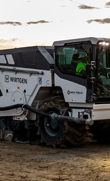 On a road building site, the following machines are lined up behind each other; Wirtgen cold recycler, John Deere crawler dozer, Wirtgen soil stabilizer and a John Deere motor grader