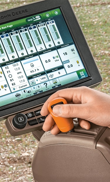Close up of a farmer’s arm and hand using the CommandARM with the Command Center Display in view behind his hand